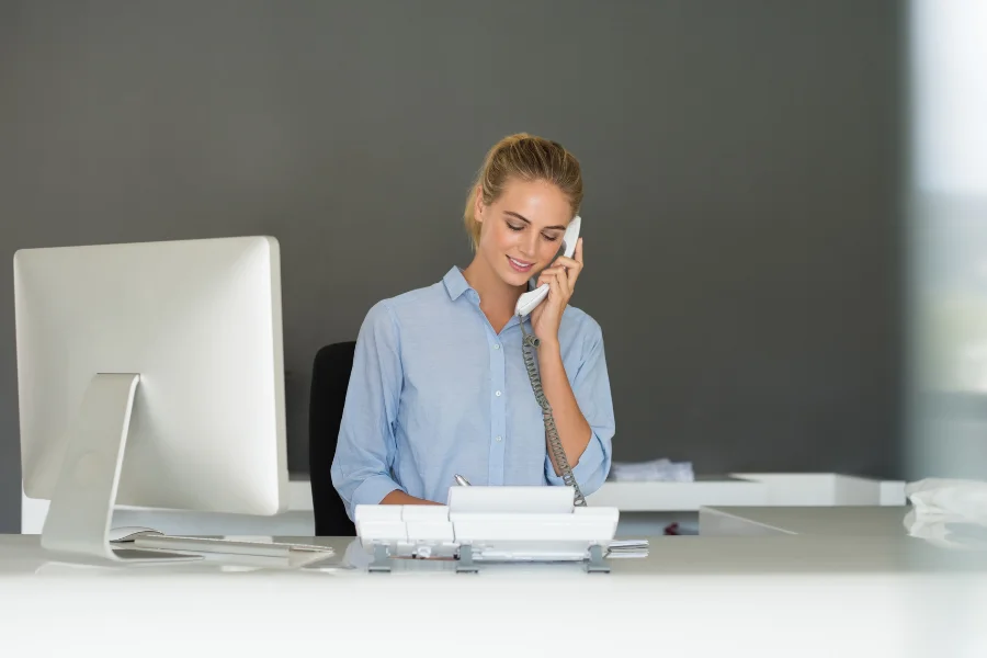 Een receptionist die tijdens het bellen de beschikbaarheid checkt