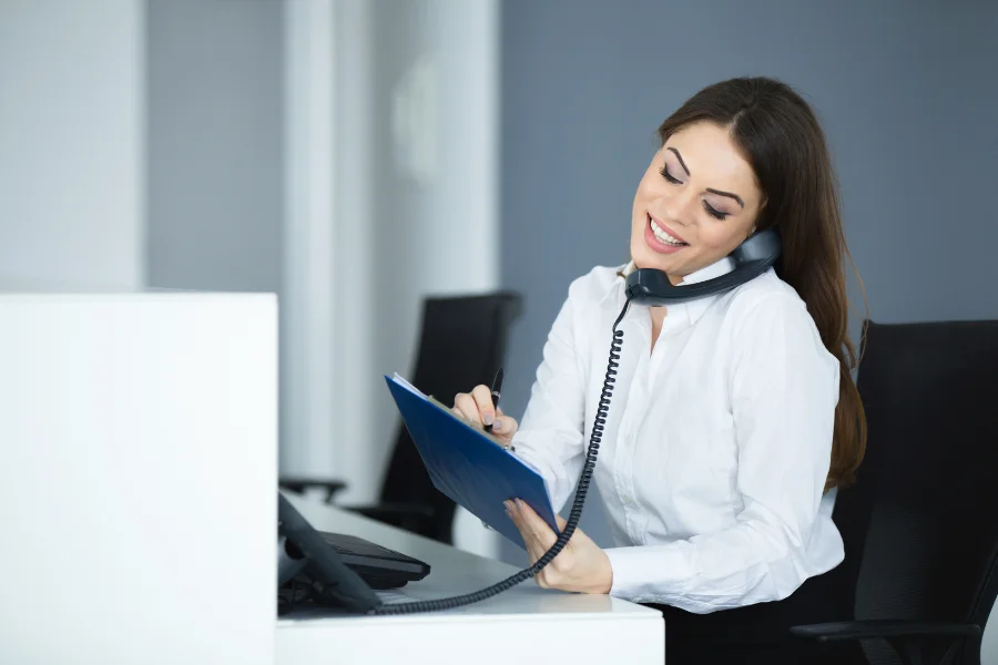 A receptionist taking a booking over the phone