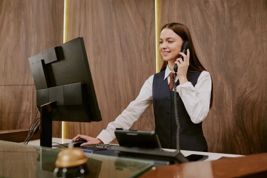 A hotel receptionist answering the phone at the front desk